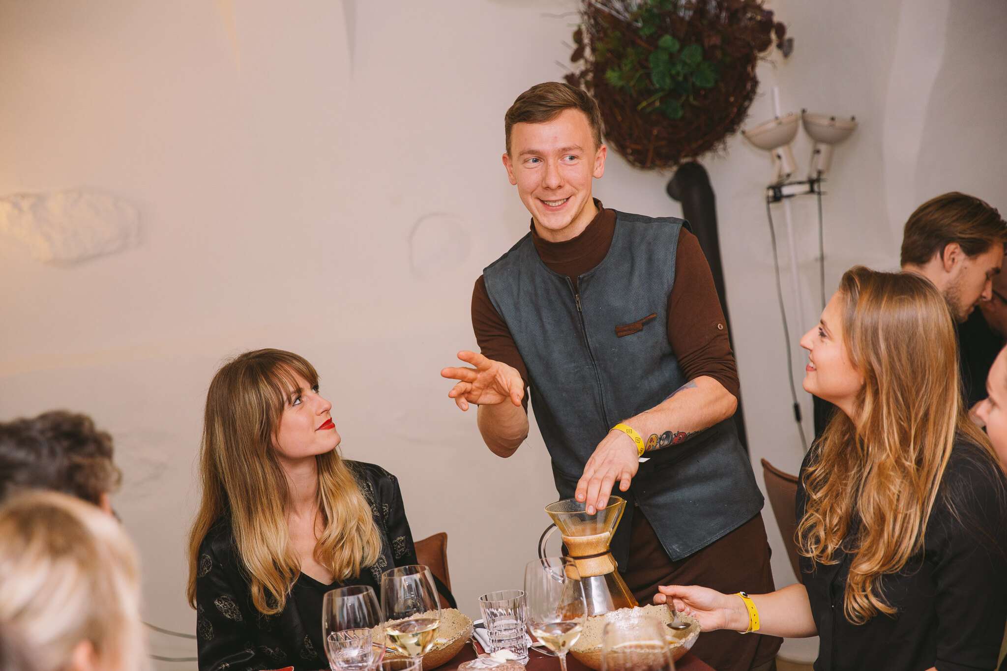 Šeimininkas vaišina svečius per jaukią vakarienę